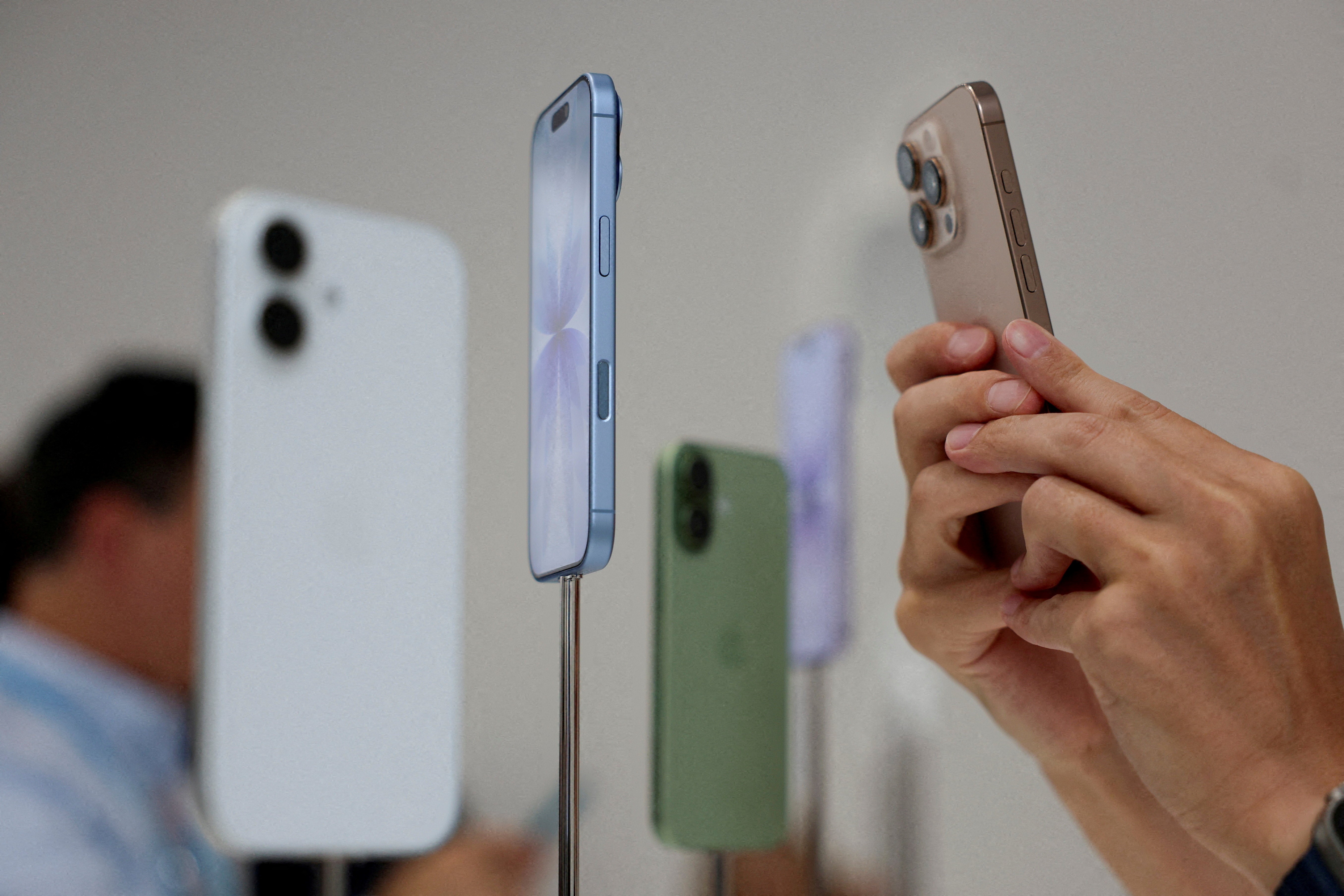 Uma pessoa usa um telefone para fotografar iPhones em exposição durante o evento da Apple. — Foto: Manuel Orbegozo/Arquivo/Reuters